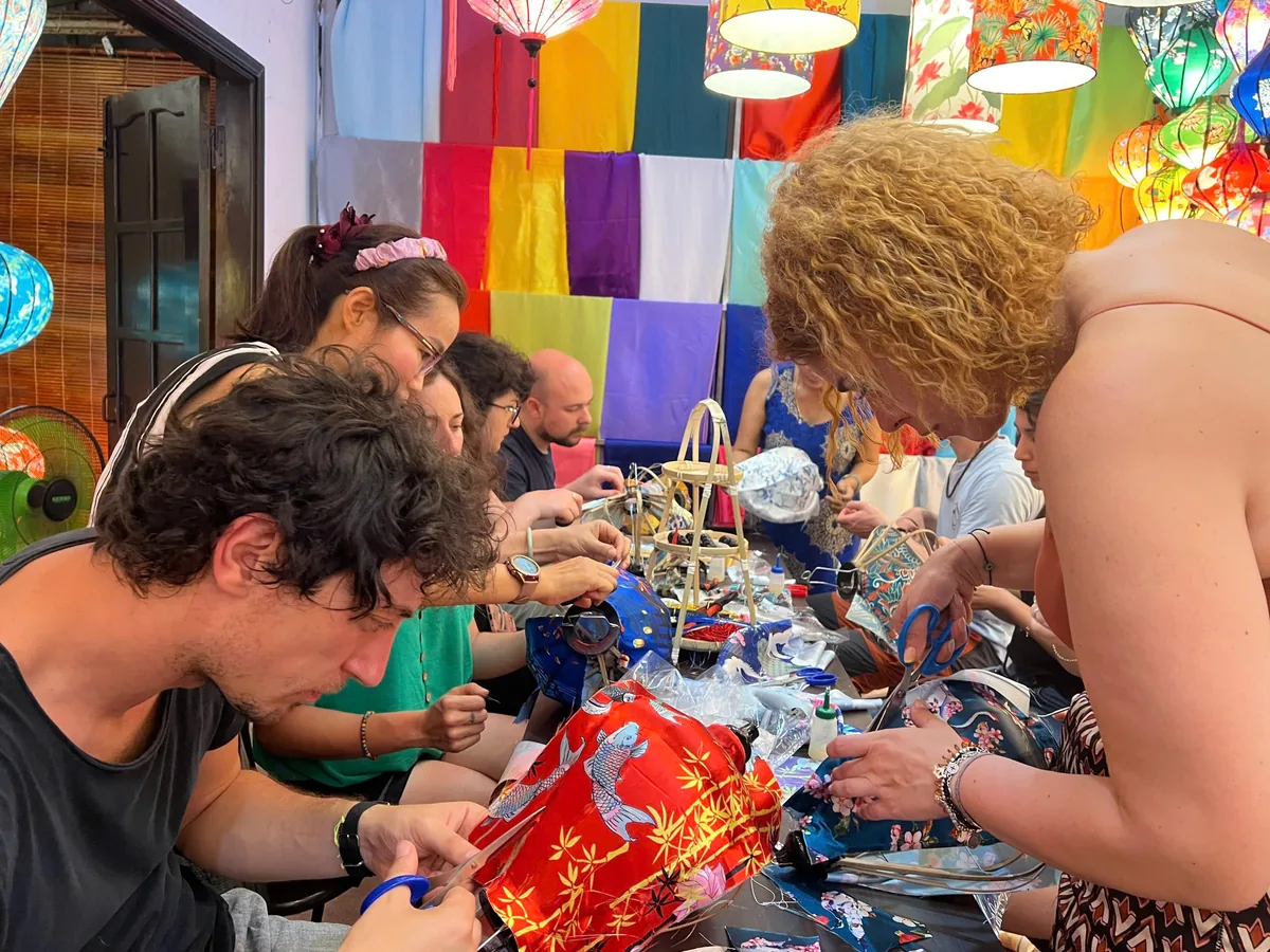 Guests applying fabric to lantern frames in the Hoi An workshop