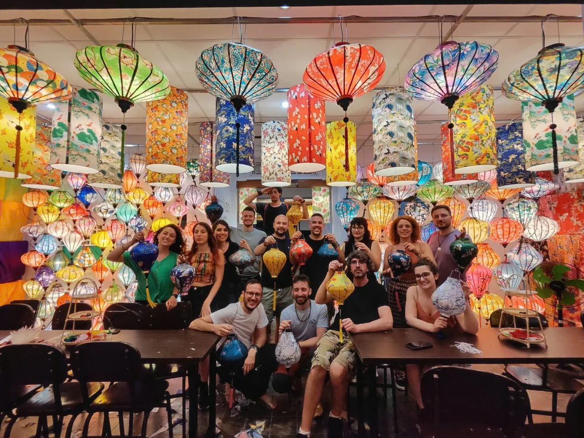 A family group holding the colourful lanterns they made in Hoi An
